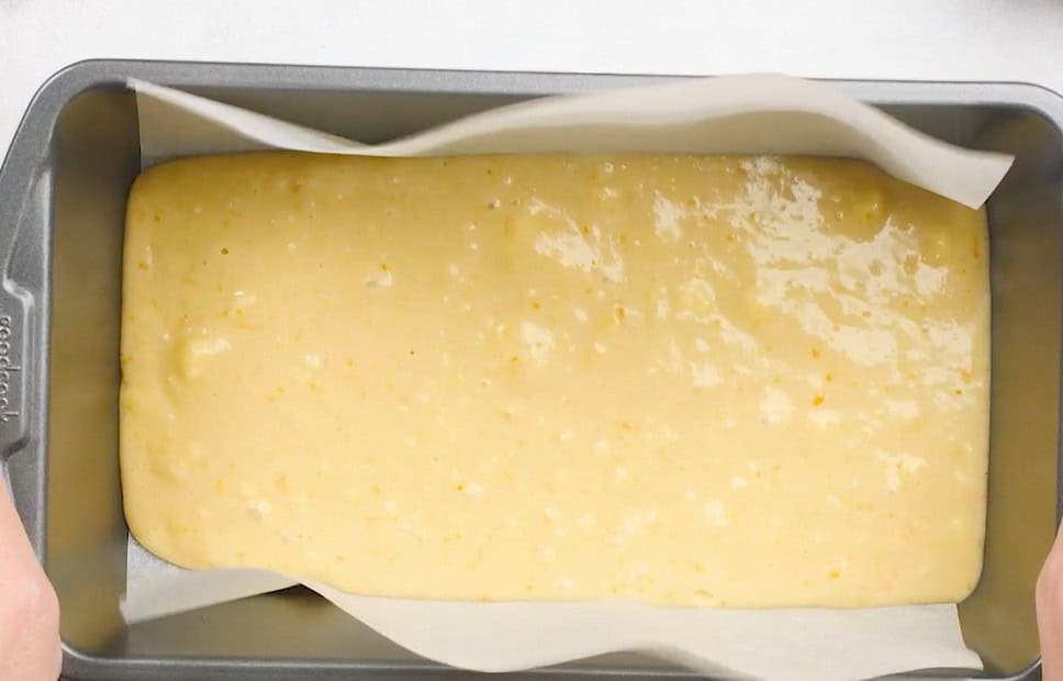 Transferring the batter to the prepared loaf pan.