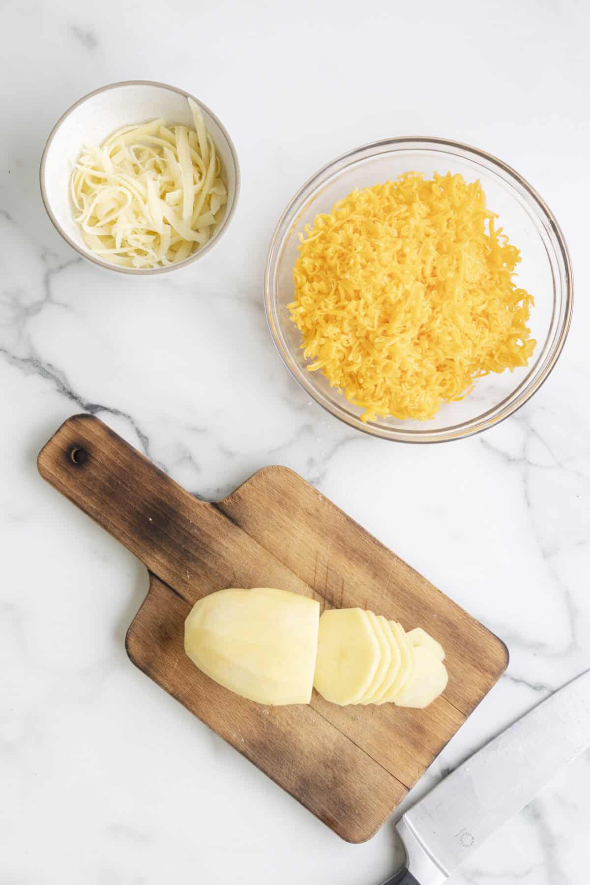 Sliced potato on a wooden cutting board.