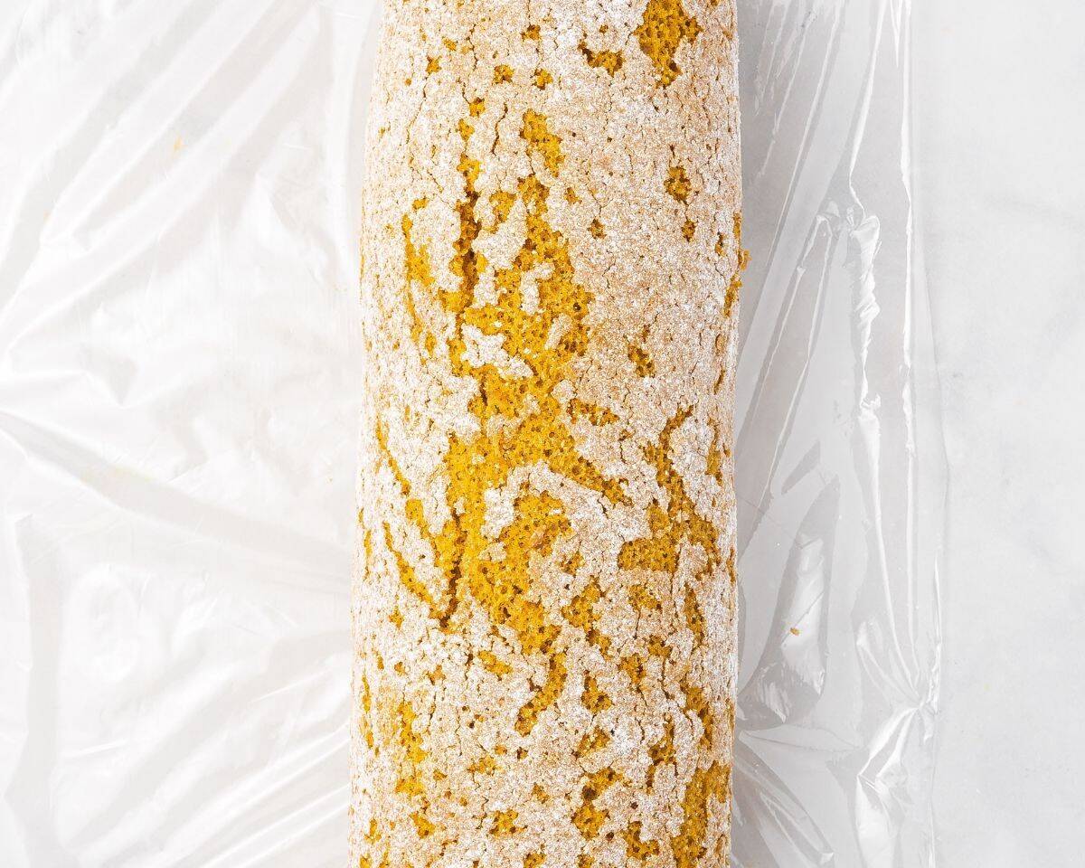 Pumpkin roll on plastic wrap.