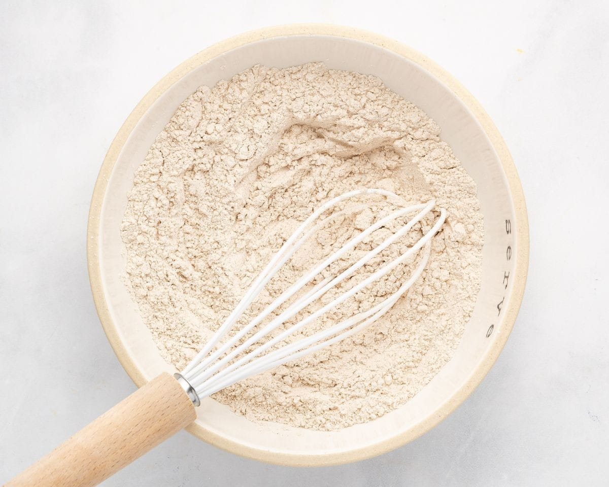 Combining the dry ingredients to make pumpkin roll cake.