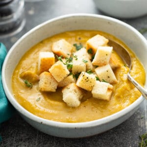 bowl of green split pea soup garnished with croutons