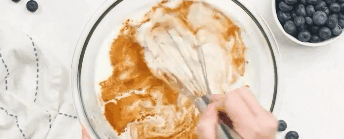 Combining the custard ingredients in a glass bowl and whisking. 