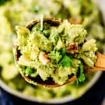 wooden serving spoonful of pasta with pesto