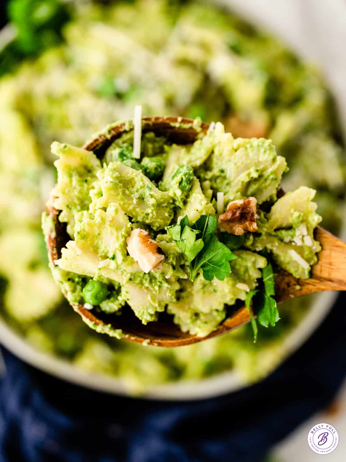 wooden serving spoonful of pasta with pesto