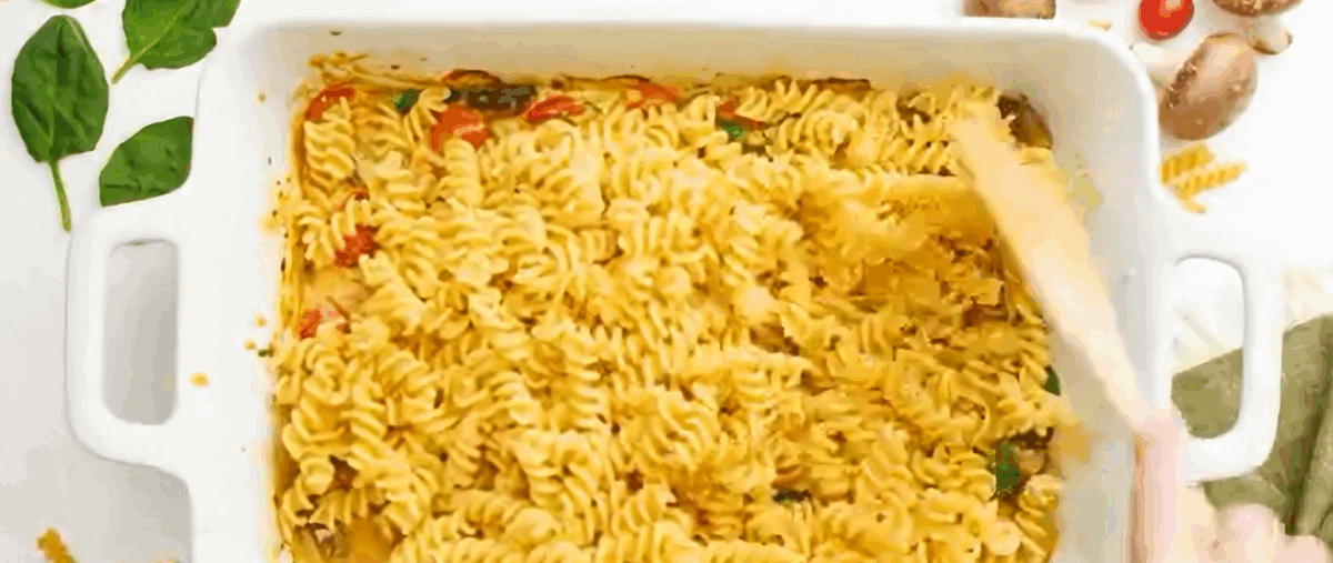 Adding pasta to the pan with the veggies and sauce. 