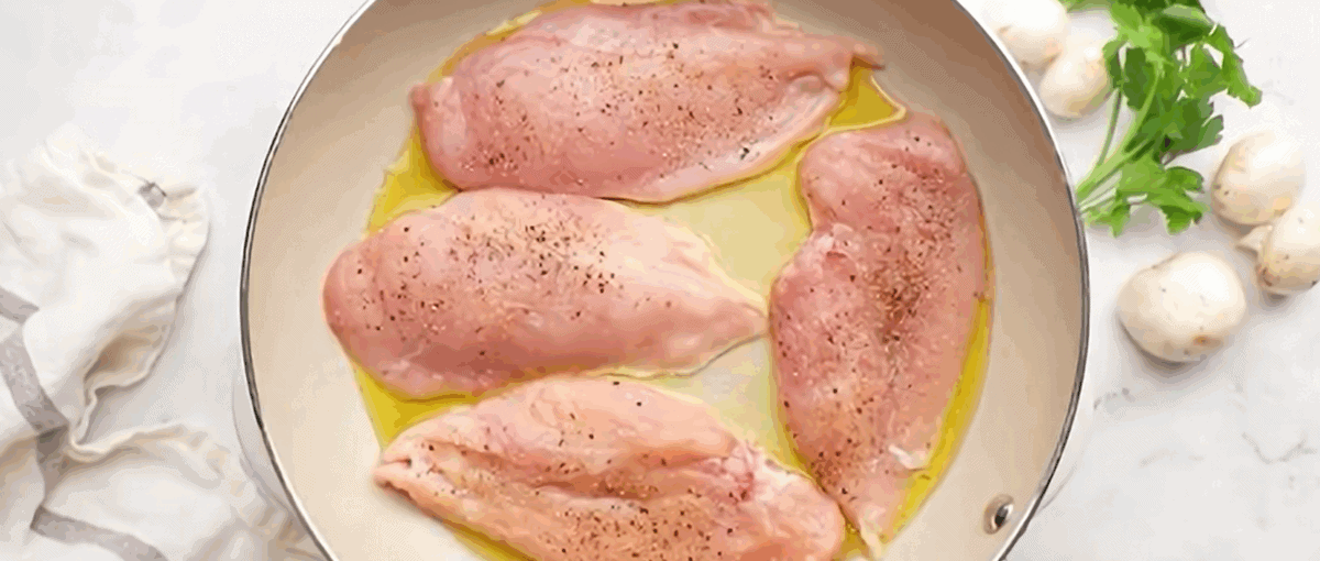 Browning the chicken cutlets in a skillet.