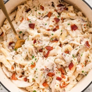 A spoon stirring chicken bacon ranch pasta