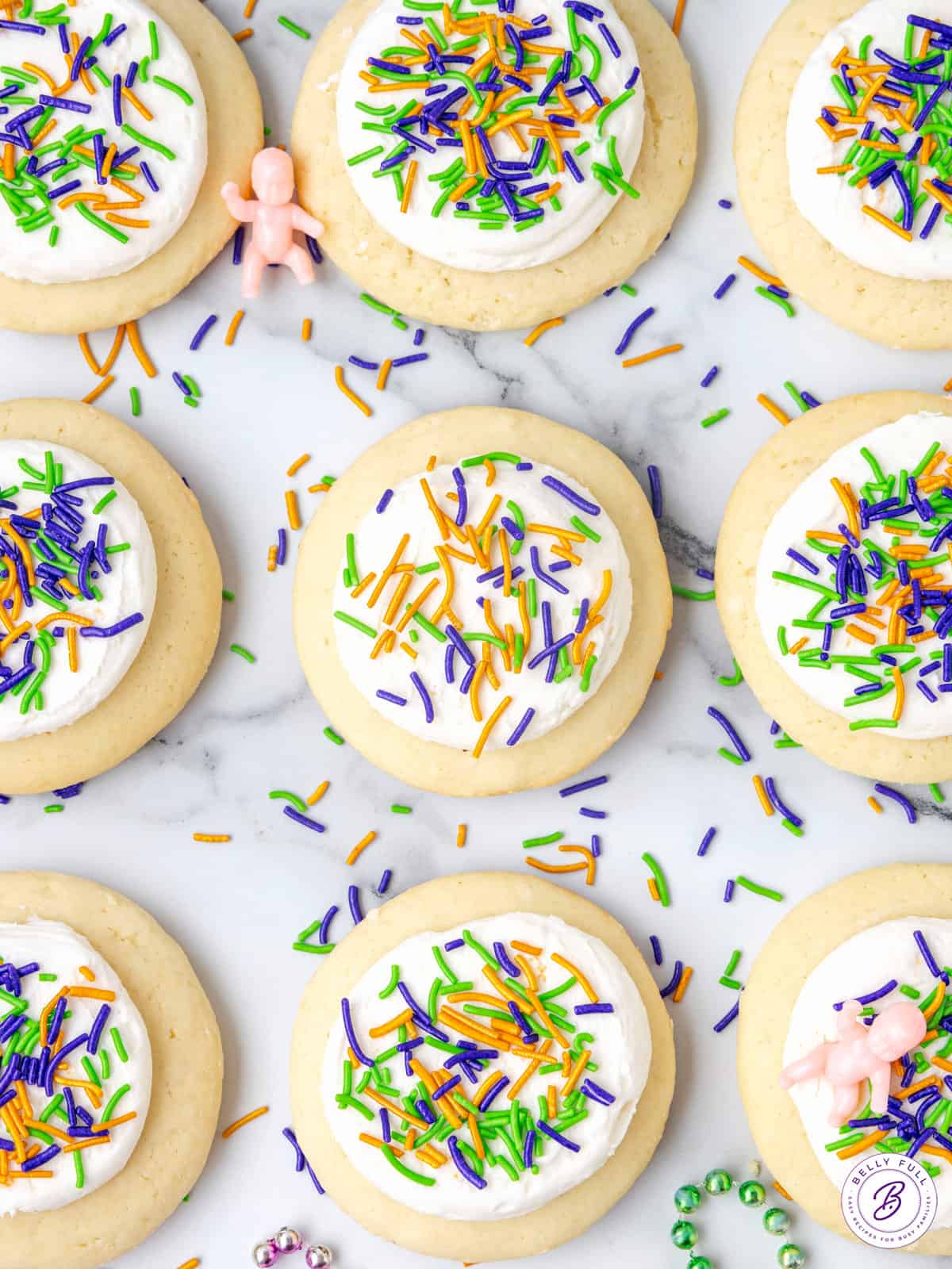 9 frosted cookies with purple, green, and gold sprinkles