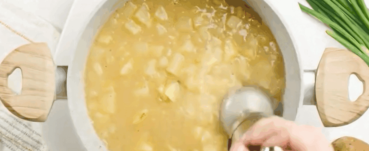 Blending the potato soup with a hand blender.