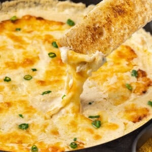 Sourdough toast dipped into hot shrimp dip