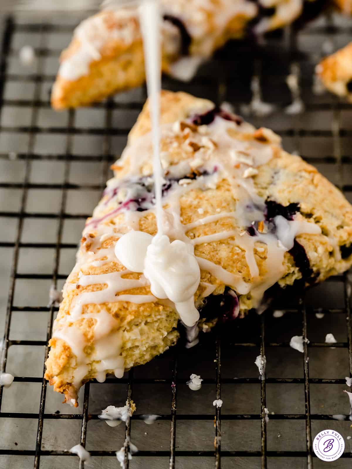 icing being drizzled on top of a scone