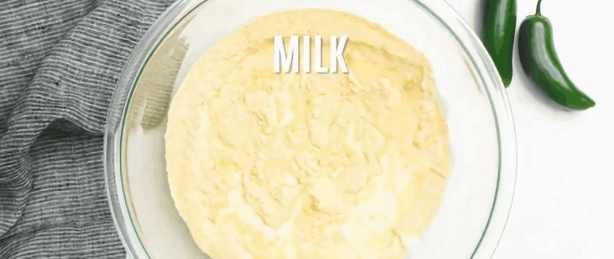 Adding the wet ingredients to the dry ingredients in a glass bowl.