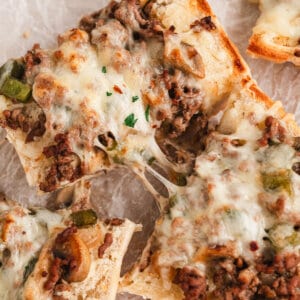 Two slices of Philly cheesesteak bread being pulled apart