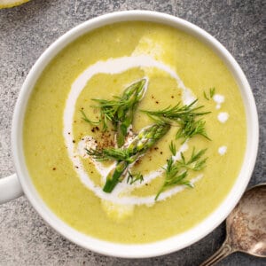 overhead cup of asparagus soup garnished with fresh dill