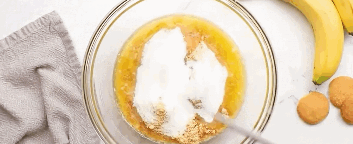 Combining the ingredients to make the crust in a glass bowl. 