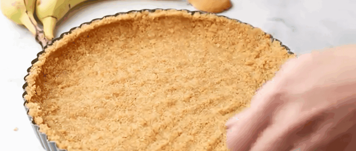 Pressing the crust into the tart pan. 