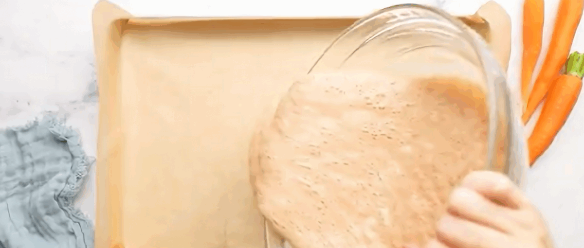 Pouring the batter into the lined cake roll pan. 