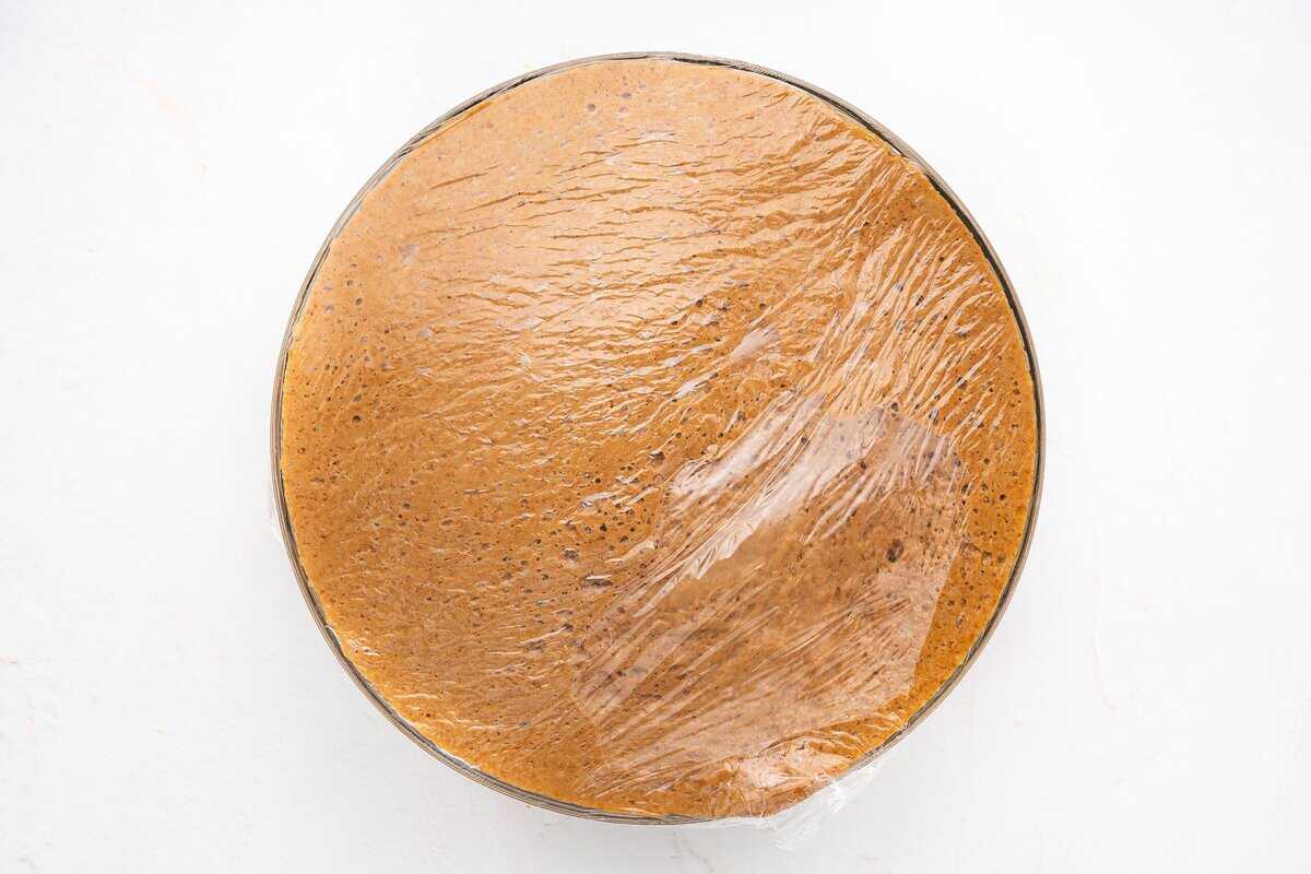 Risen dough covered with plastic wrap.