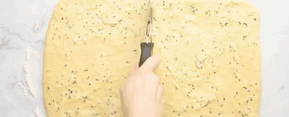 Spreading the filling over the dough and cutting the dough with a pizza cutter.