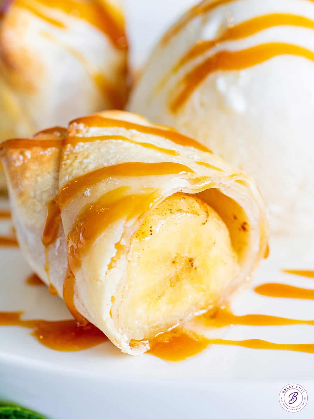 banana lumpia cut in half drizzled with caramel sauce