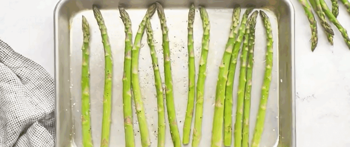 Asparagus spears on a baking sheet.