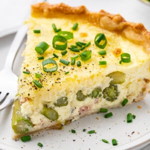 A slice of asparagus quiche on a plate