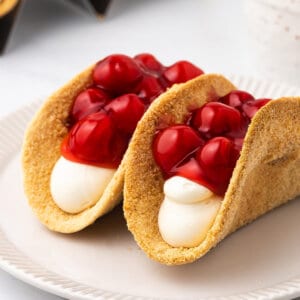 Two cherry cheesecake tacos on a plate