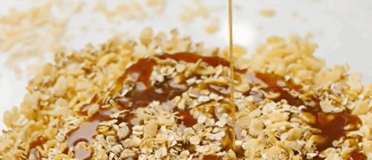 Pouring the sugar mixture over the oat mixture. 