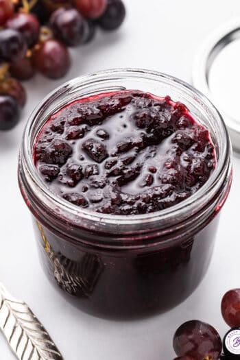 Overhead view of a glass jar of homemade grape jam