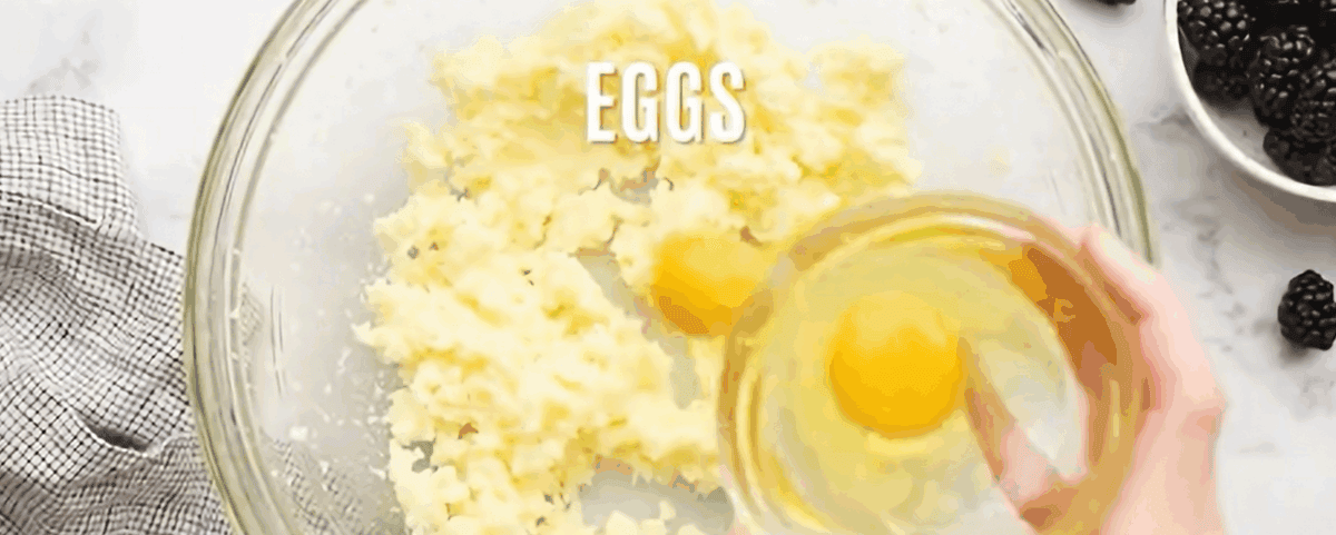 Adding the eggs to the butter and sugar mixture.