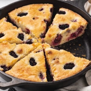 sliced cake with blackberries in cast iron skillet