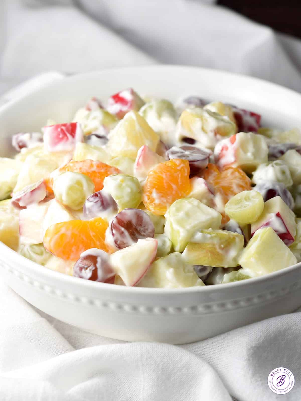 creamy deli fruit salad in white bowl