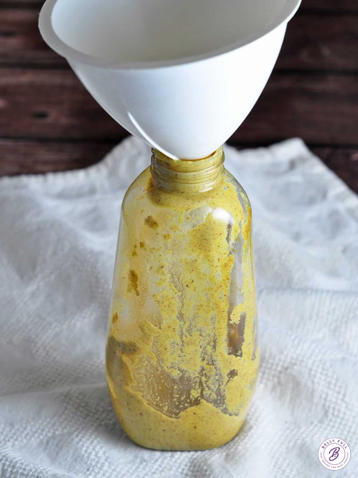 empty mustard container with funnel on top