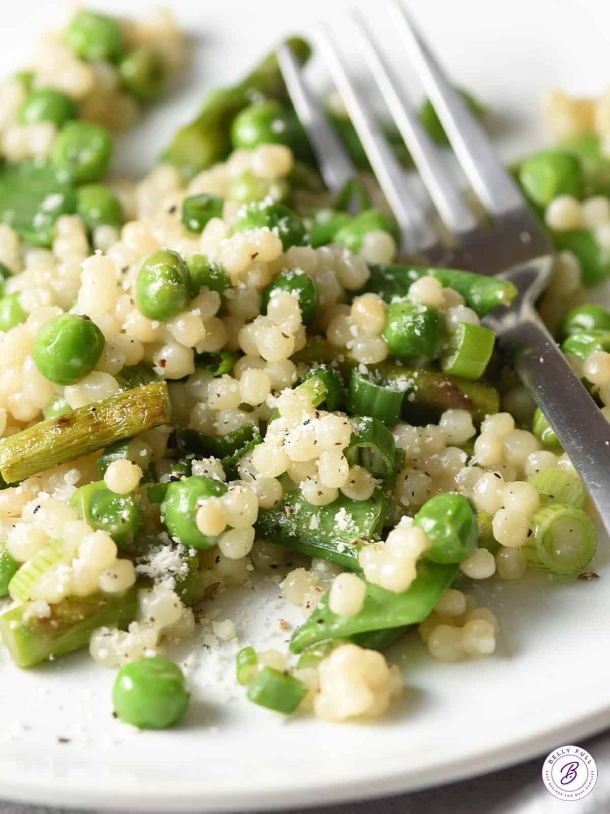 close up couscous with baby peas on plate