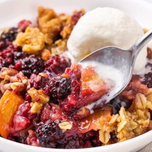spoonful of mixed fruit crisp with ice cream