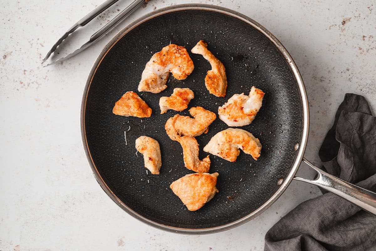 Cooking the chicken strips in a skillet. 