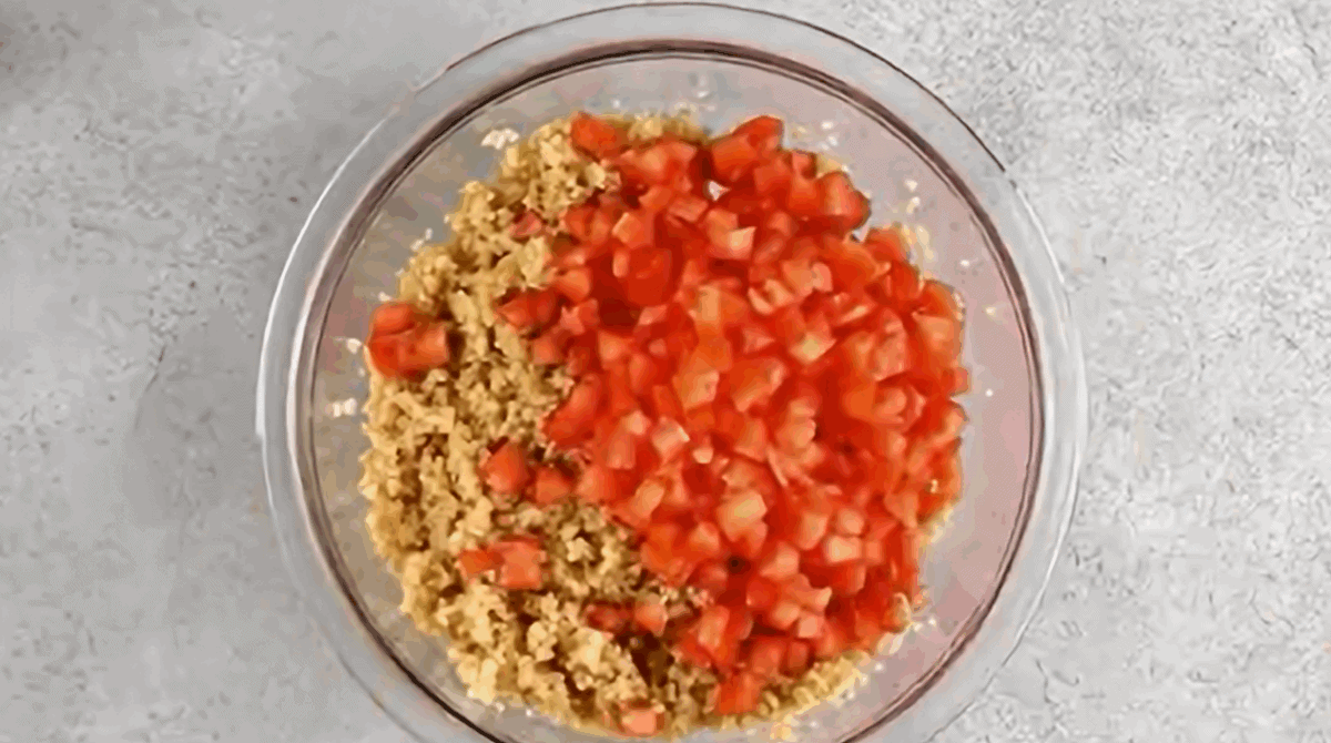 Adding chopped tomatoes to the soaked bulghur.