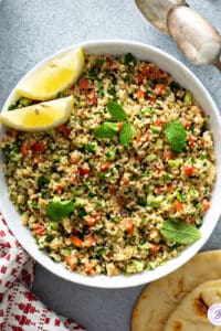 overhead bowl of Tabbouleh with lemon wedges