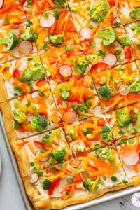 overhead sheet tray of sliced cold veggie pizza