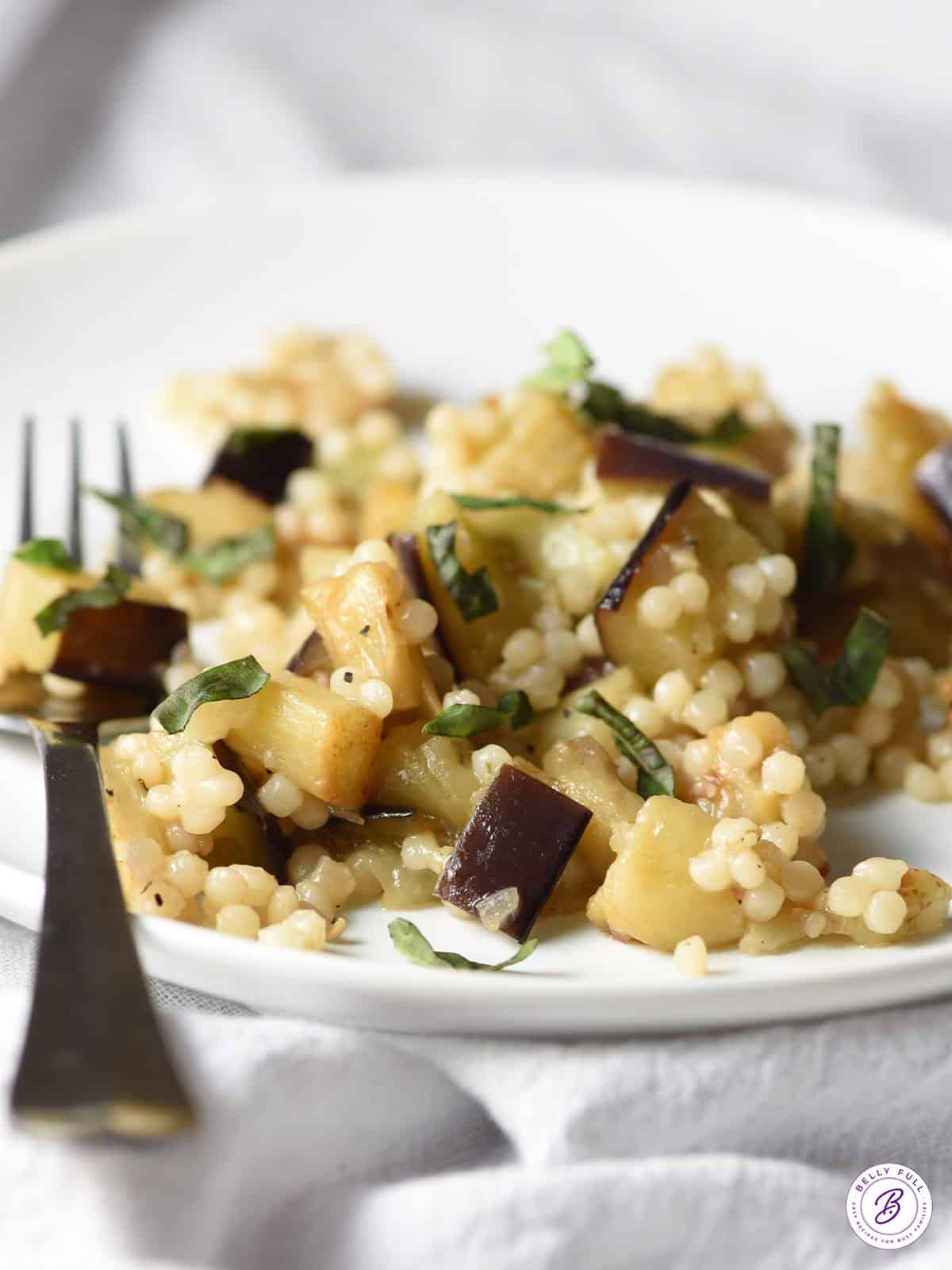 eggplant couscous with torn basil on plate