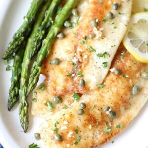overhead fish piccata on plate with garlic and capers