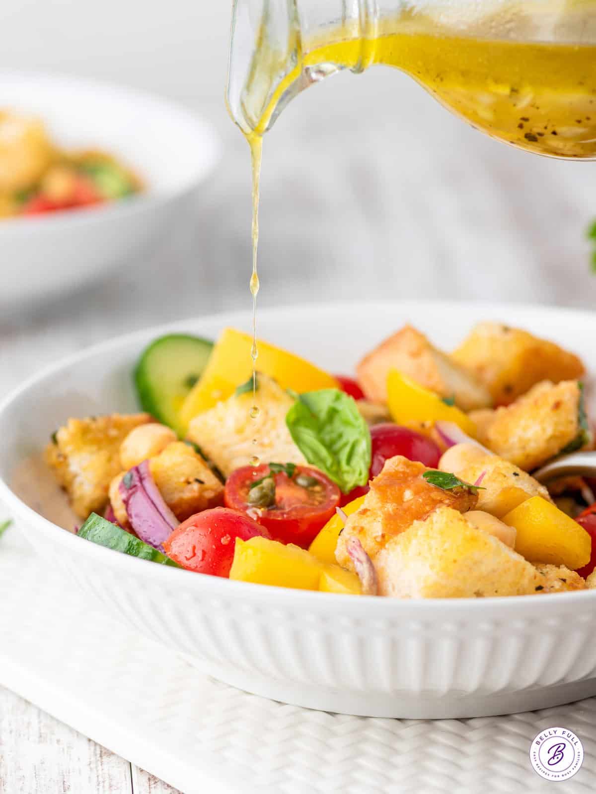 vinaigrette being poured over salad