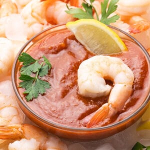 A dish of cocktail sauce surrounded by shrimp