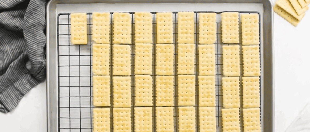 Placing club crackers on the sprayed wire rack.