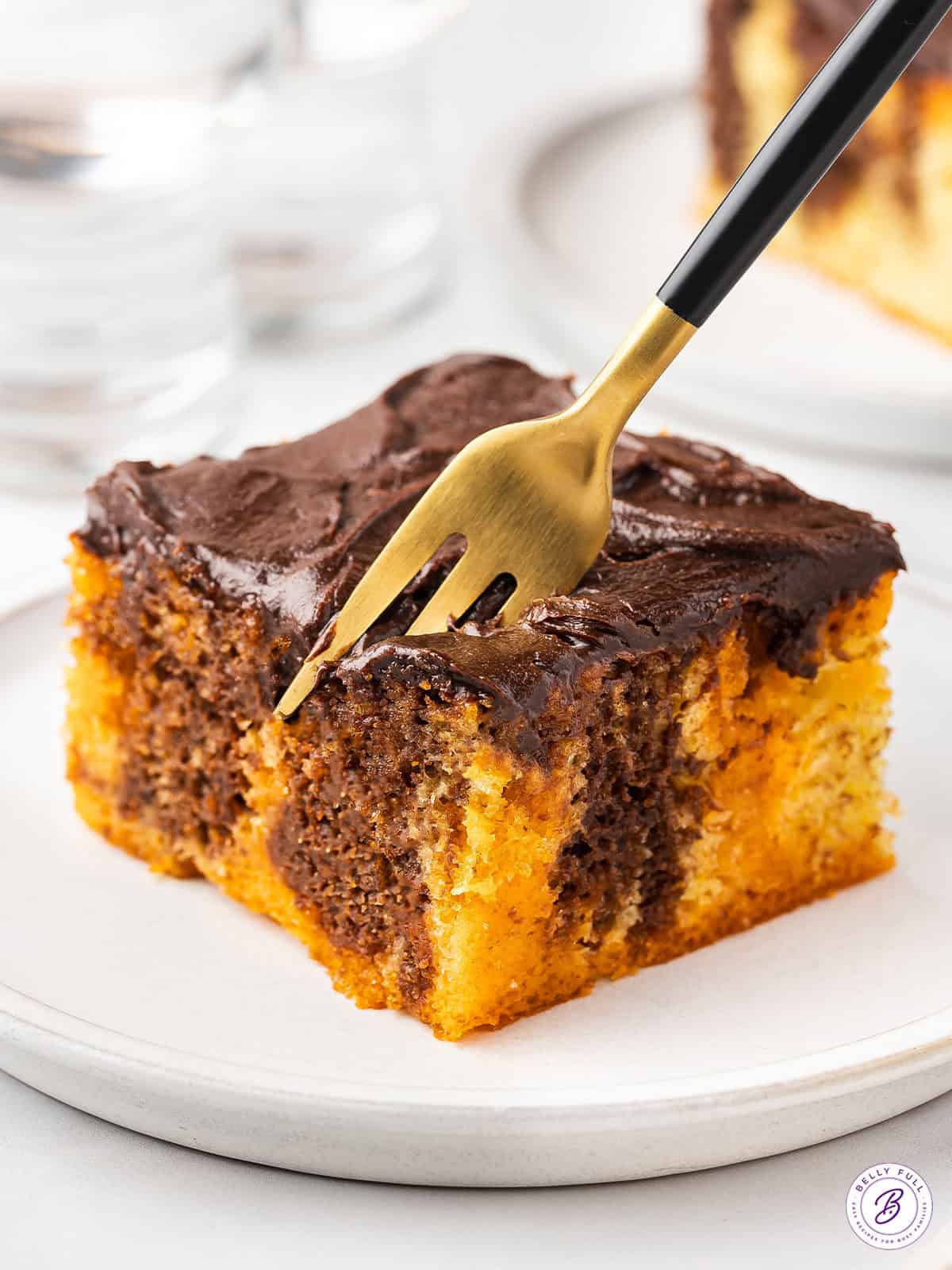 orange and chocolate piece of cake on plate with fork