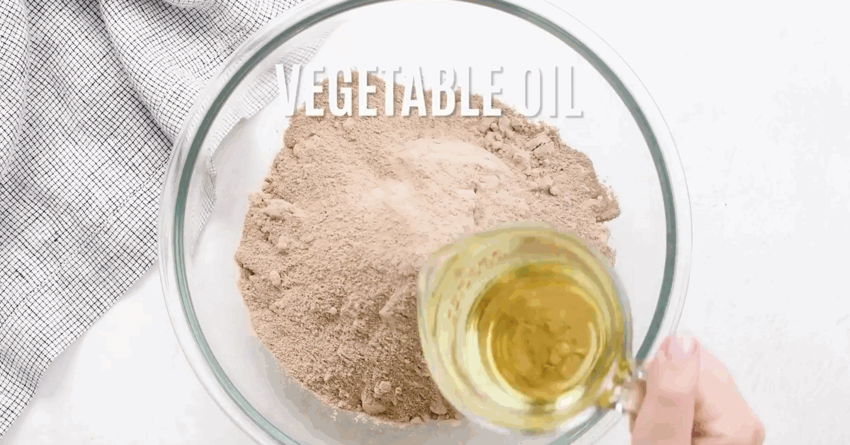 Combining the ingredients for the cake mix in a glass bowl.