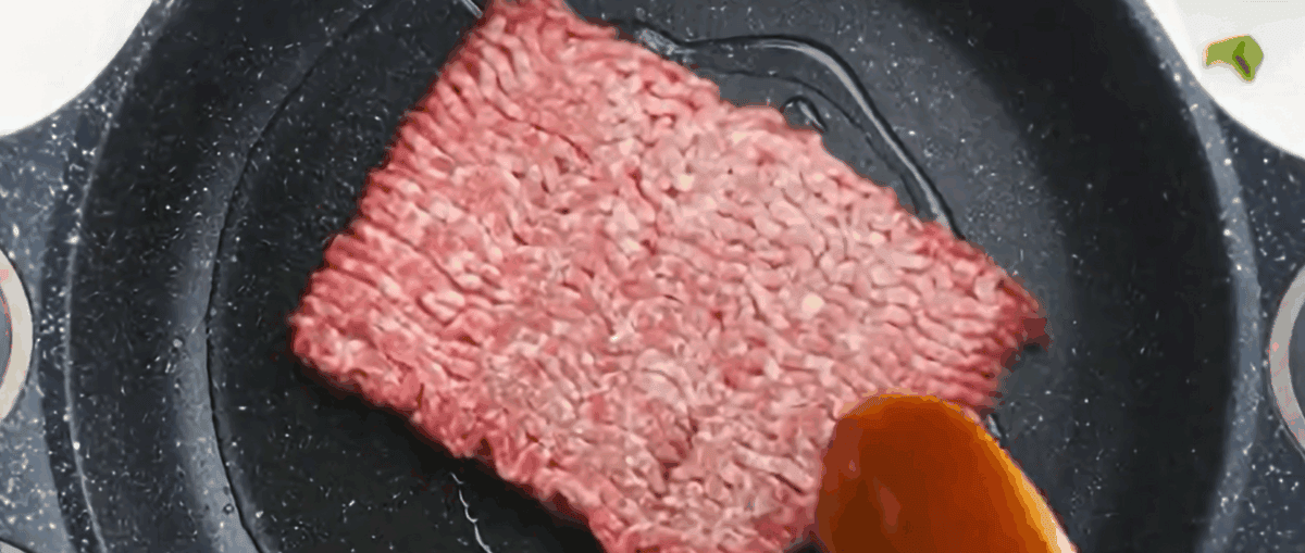 Cooking ground pork in a skillet. 