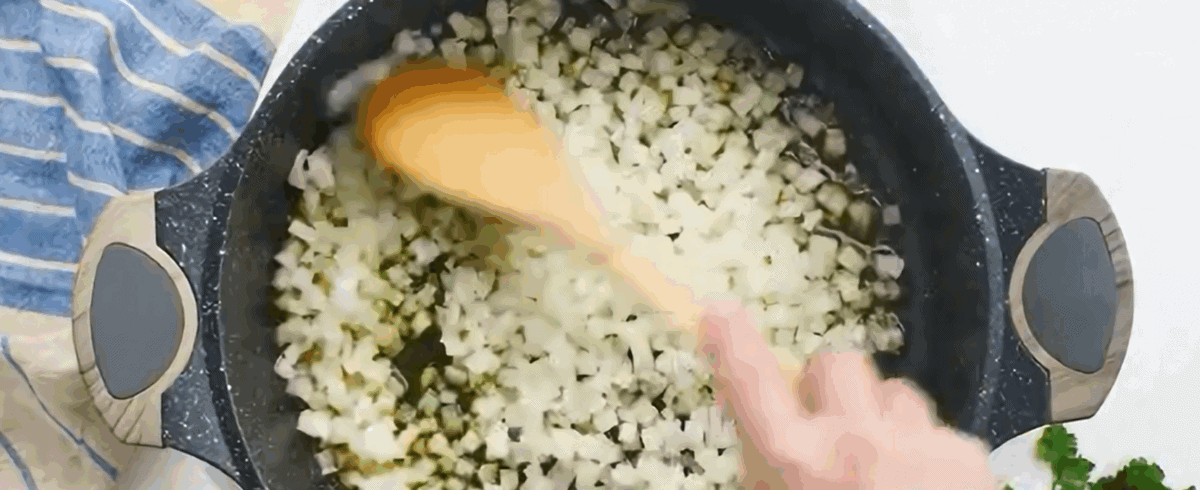 Cooking onions in a black skillet.