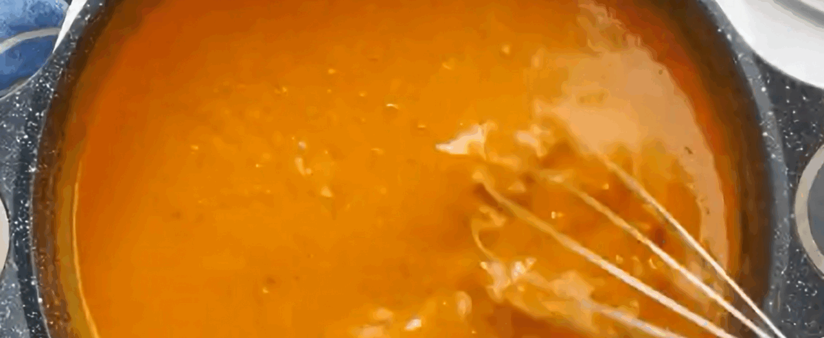 Adding sour cream and heavy cream mixture to the sauce and stirring.