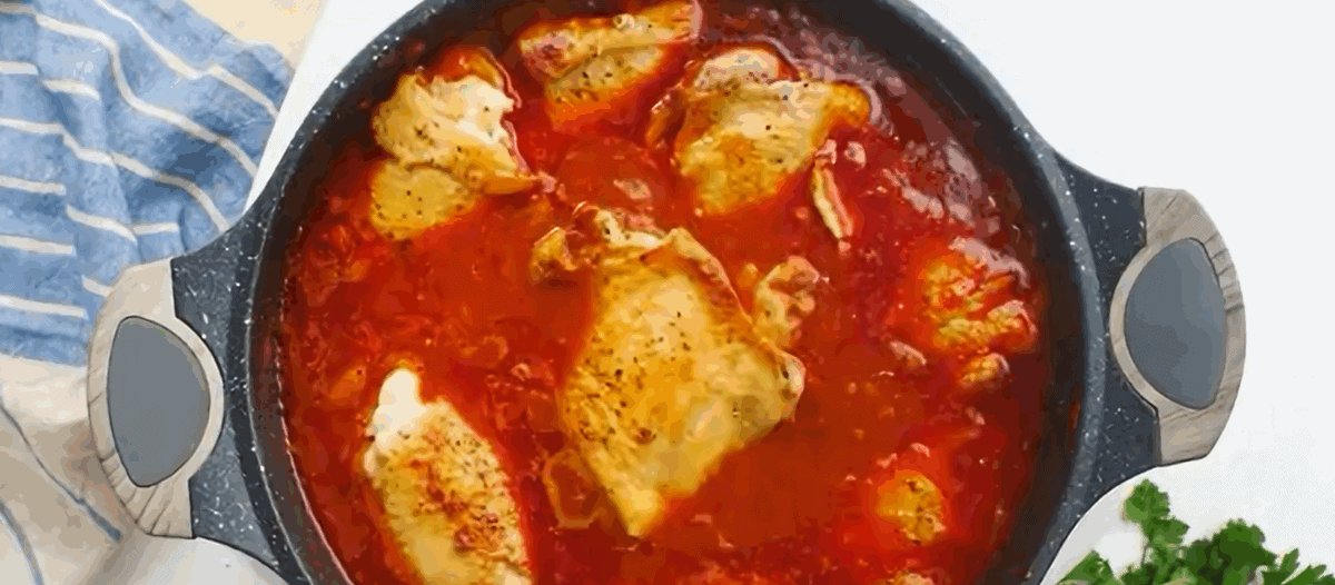 Adding the chicken to the pot with the sauce to simmer.